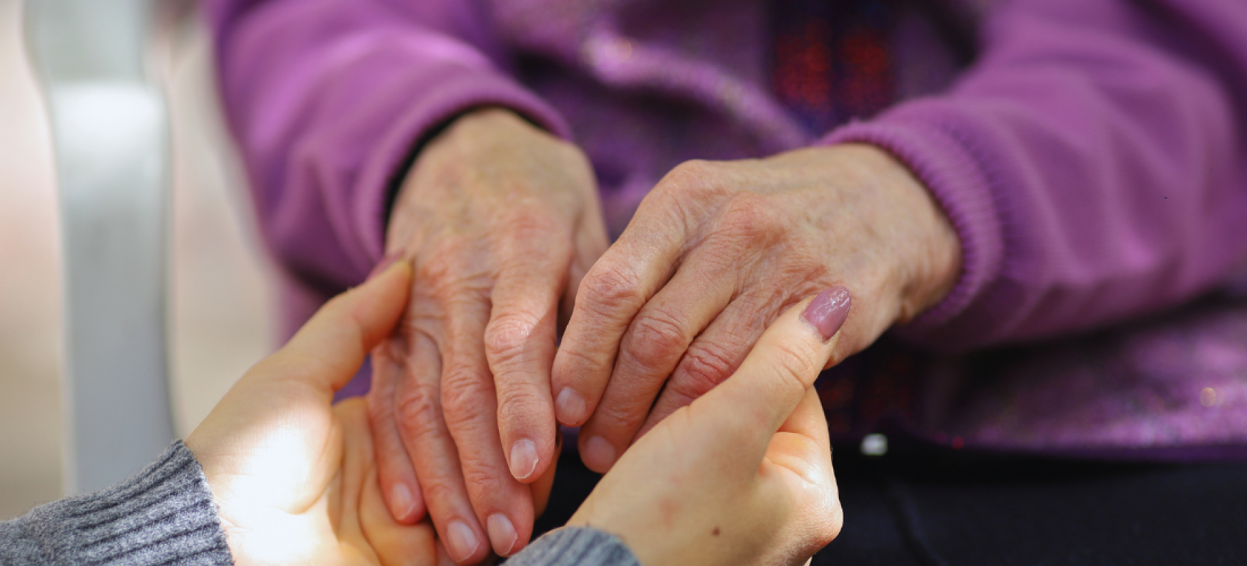 noor hooldustöötaja hoidmas eaka käsi